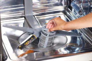 Hand cleaning a dishwasher filter — regular maintenance for better performance and hygiene