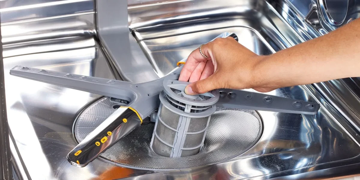 Hand cleaning a dishwasher filter — regular maintenance for better performance and hygiene