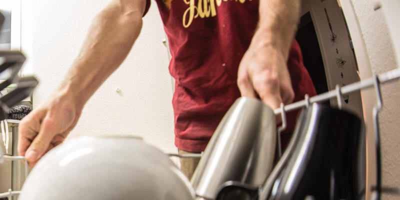 Home appliance repair: a young man loading a dishwasher