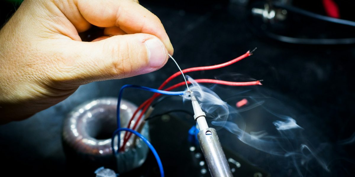 man soldering wires